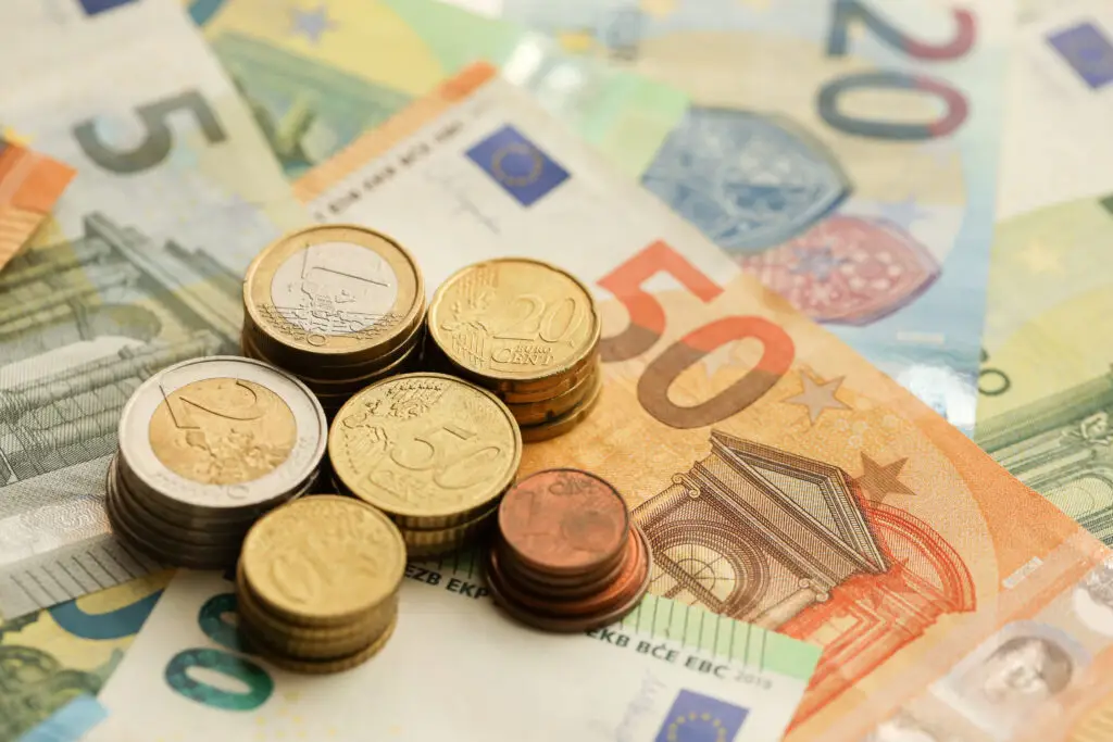 Euro novčanice i kovanice položene na stolu.