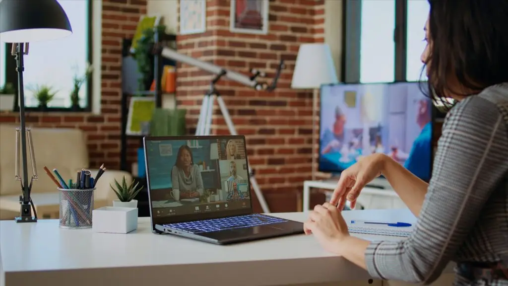 Osoba sudjeluje u online sastanku putem prijenosnog računala, što simbolizira webinar, videokonferenciju i digitalnu edukaciju.